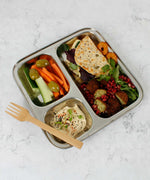 A Slice Of Green Stainless Steel Divided Plate. The plate has hummus in the smallest section, carrot, cucumber and olives in the middle section and flatbread, salad and falafels in the biggest section. This stainless steel plate is suitable for snacks and meals and perfect for children and adults. 