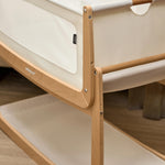 A closeup of the corner of the natural wooden SnuzPod5 bedside crib, showing where the bassinet can detach from the main rocking frame. 