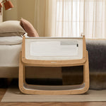 The SnuzPod 5 bedside baby crib with a lovely natural wooden frame, next to an adult's bed in a beautifully decorated bedroom.