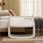 The SnuzPod 5 bedside baby crib with a lovely white wooden frame, next to an adult's bed in a beautifully decorated bedroom.