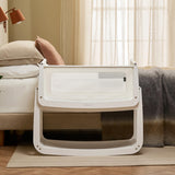 The SnuzPod 5 bedside baby crib with a lovely white wooden frame, next to an adult's bed in a beautifully decorated bedroom.