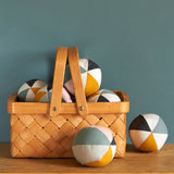 A child happily playing with the Roommate Canvas Sensory Ball - Rose