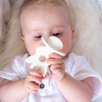  looking up and holding the Sophie la Girafe natural rubber teether