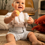 A child happily playing and holding the yellow and white musical balls from the Sophie The Giraffe - Once Upon A Time 5 Senses Musical Balls set