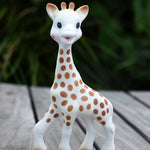  looking down and holding the Sophie la Girafe® - Once Upon A Time 100% Natural Rubber Original Giraffe Teether