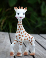  looking down and holding the Sophie la Girafe® - Once Upon A Time 100% Natural Rubber Original Giraffe Teether