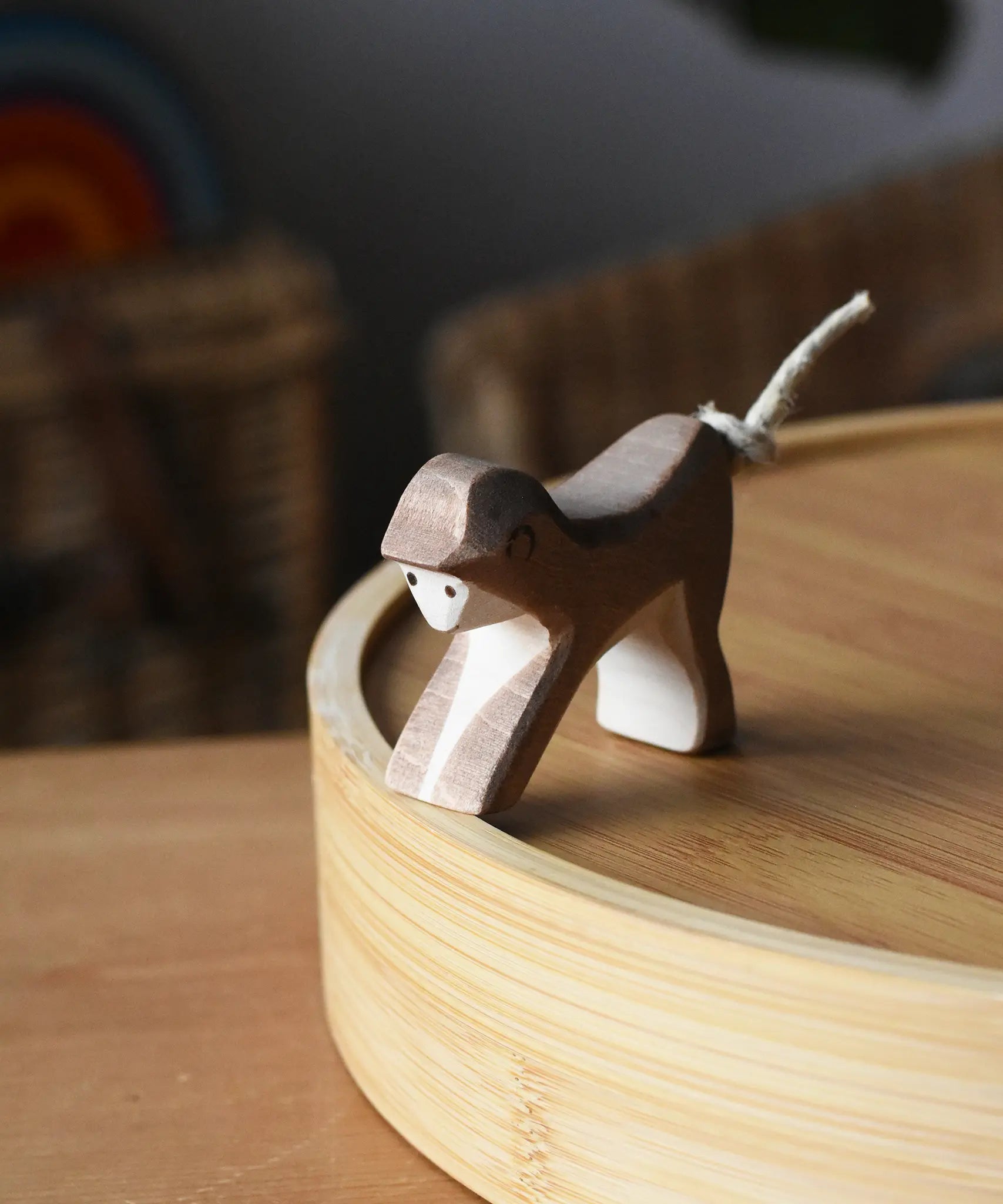 Ostheimer monkey wooden toy figure placed on a bamboo tray. 