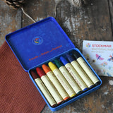 Stockmar 8 Standard Colour assortment Wax Crayons in a tin. Carmine red, orange, lemon yellow, green, blue violet, rust and black coloured wax crayon sticks.