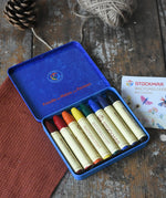 Stockmar 8 Standard Colour assortment Wax Crayons in a tin. Carmine red, orange, lemon yellow, green, blue violet, rust and black coloured wax crayon sticks.