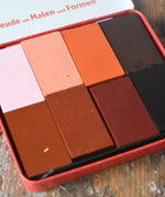 Close up of Stockmar colours of the world skin tone colour wax blocks crayons in a metal storage tin. 