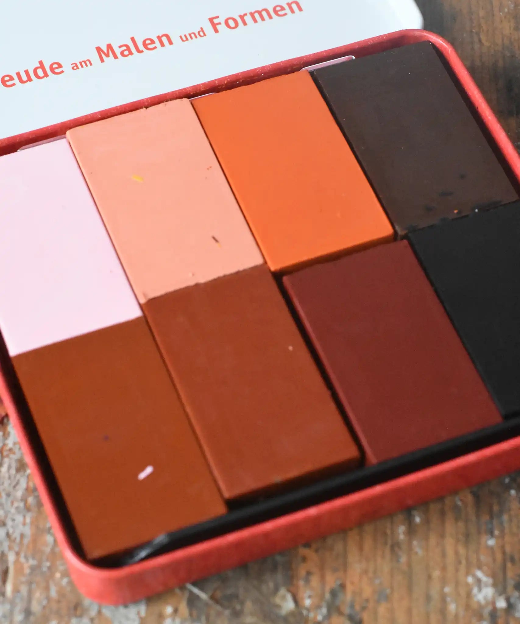Close up of Stockmar colours of the world skin tone colour wax blocks crayons in a metal storage tin. 