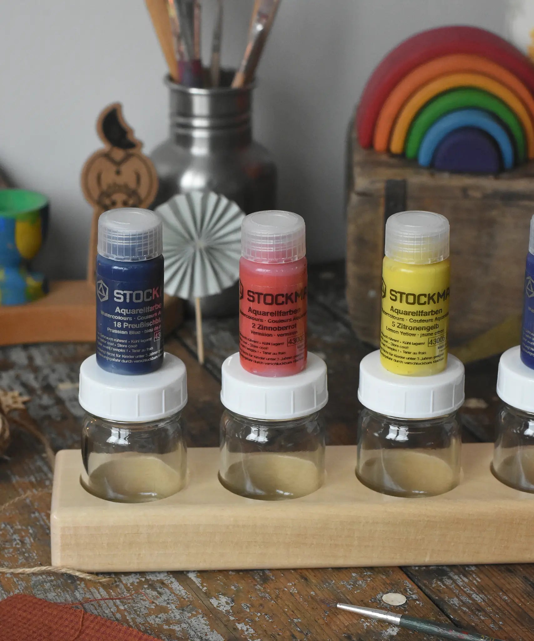 Stockmar 20ml concentrated watercolour paint pots placed on top of the glass jars.