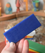 Blue sheet of Stockmar modelling beeswax in an adult's hand.