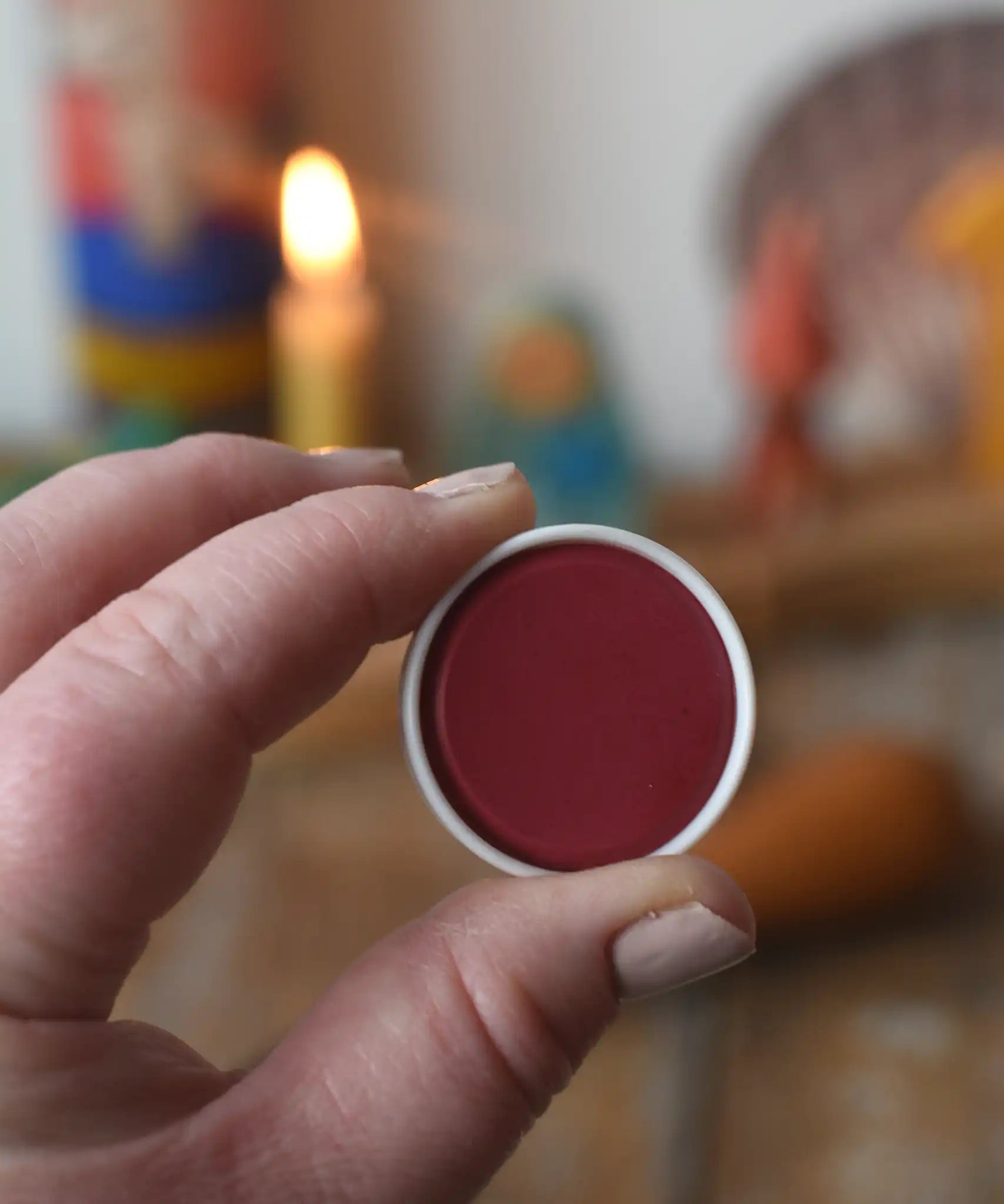 Stockmar red opaque watercolour replacement tablet in an adult's hand.