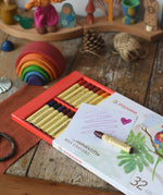 Stockmar 32 wax crayons stick set pack. Simple line and a heart drawn on a piece of paper placed on top of the box.