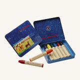 Stockmar 8 Standard Colour assortment Wax Crayons in a tin. Carmine red, orange, lemon yellow, green, blue violet, rust and black coloured wax crayon sticks with a wax scraper in a blue coloured metal tin storage box. 