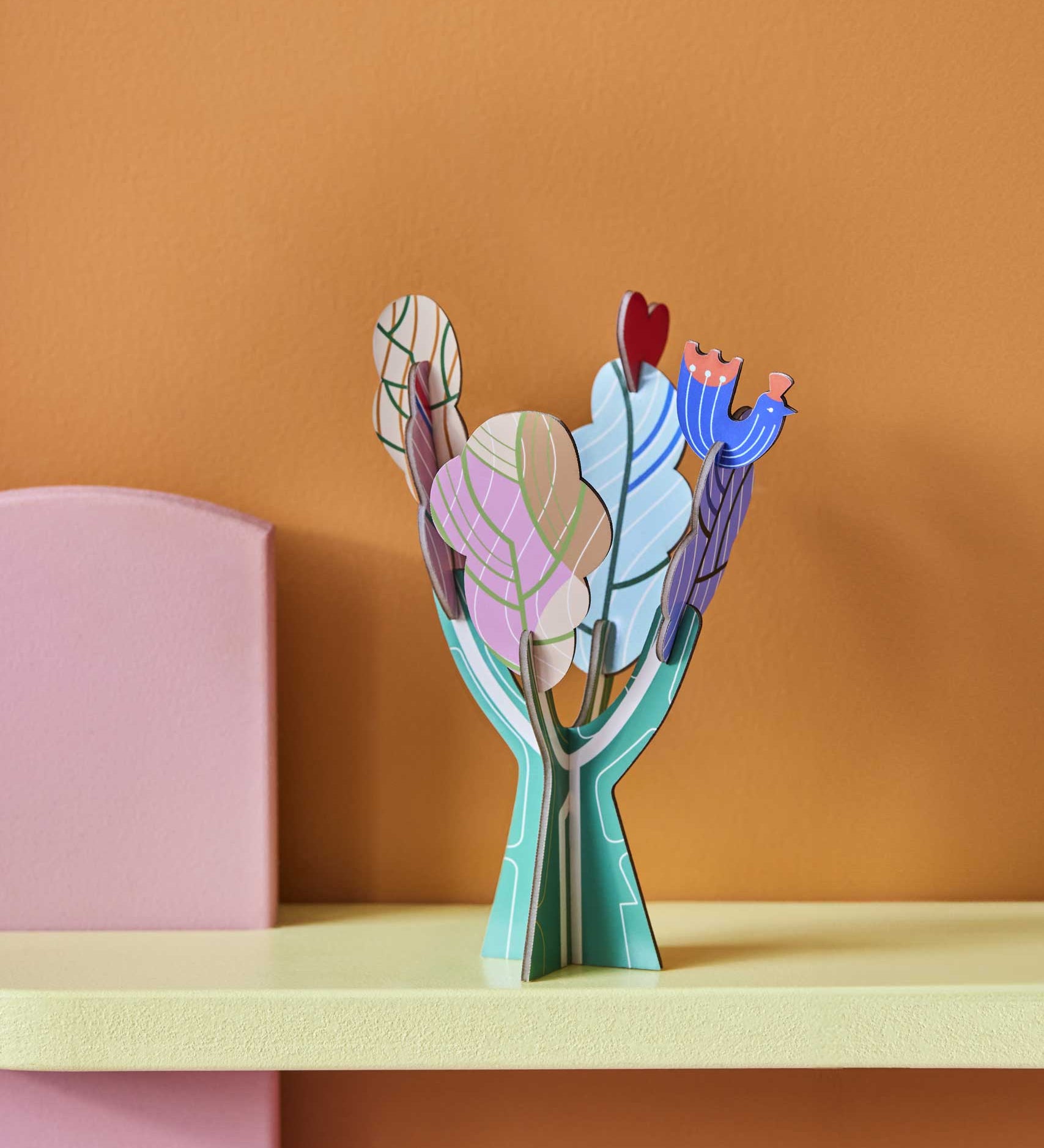 Studio Roof 3D Pop Out Card Tree of Life decoration placed on a shelf. A cardboard DIY craft kit that comes with a card. This kit is part of a wide range of Studio Roof kits that are available at Babipur.