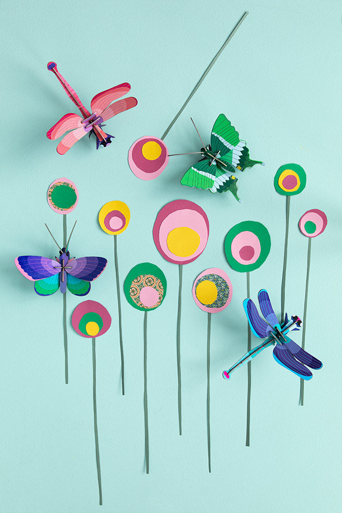 Studio Roof insects collection mounted on a pink panel of a colourful wall with a blue painted ladder