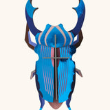 A Studio Roof 3D azure stag beetle cardboard wall art fully assembled with a metallic finish on the pieces.