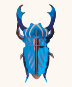 A Studio Roof 3D azure stag beetle cardboard wall art fully assembled with a metallic finish on the pieces.