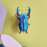 Studio Roof 3D cardboard azure stag beetle craft kit displayed on a wall 