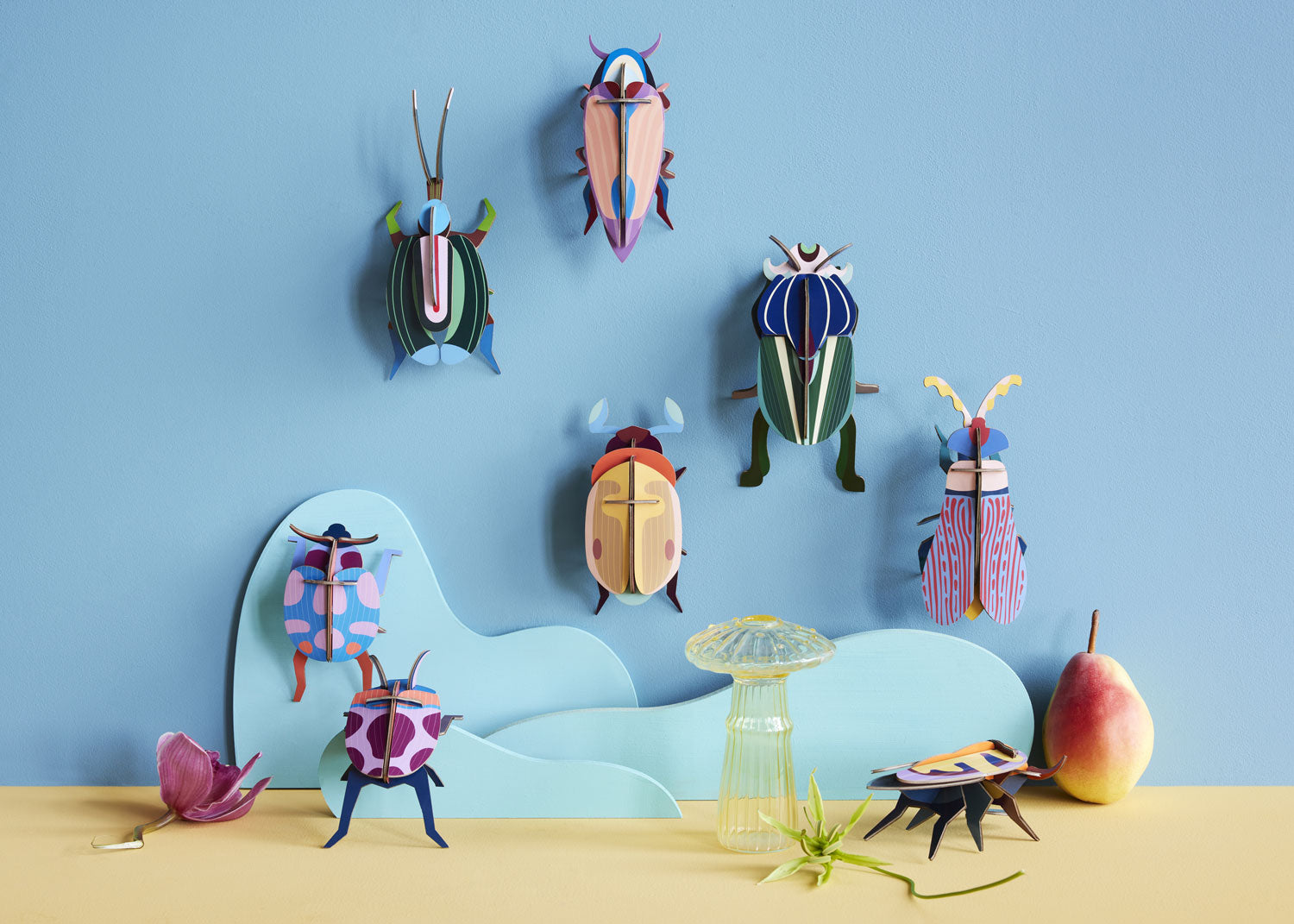 Studio Roof beetles and insects hung up on a blue coloured wall