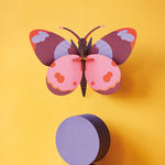 Studio roof bellissima butterfly wall decoration hanging on a yellow wall above a purple circle block