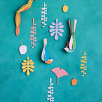 Studio Roof Paradise Nest craft bird wall hangings on a blue wall surrounded by card leaves