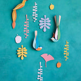 Studio Roof Paradise Nest craft bird wall hangings on a blue wall surrounded by card leaves