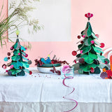 Studio Roof Large cardboard Christmas Tree & cardboard Squirrel Decor in the front and a smaller Christmas Tree with a cardboard peacock in a fruit bowl on a table