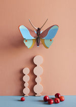 Studio Roof Claudina Butterfly decoration pictured on a peach coloured  painted wall