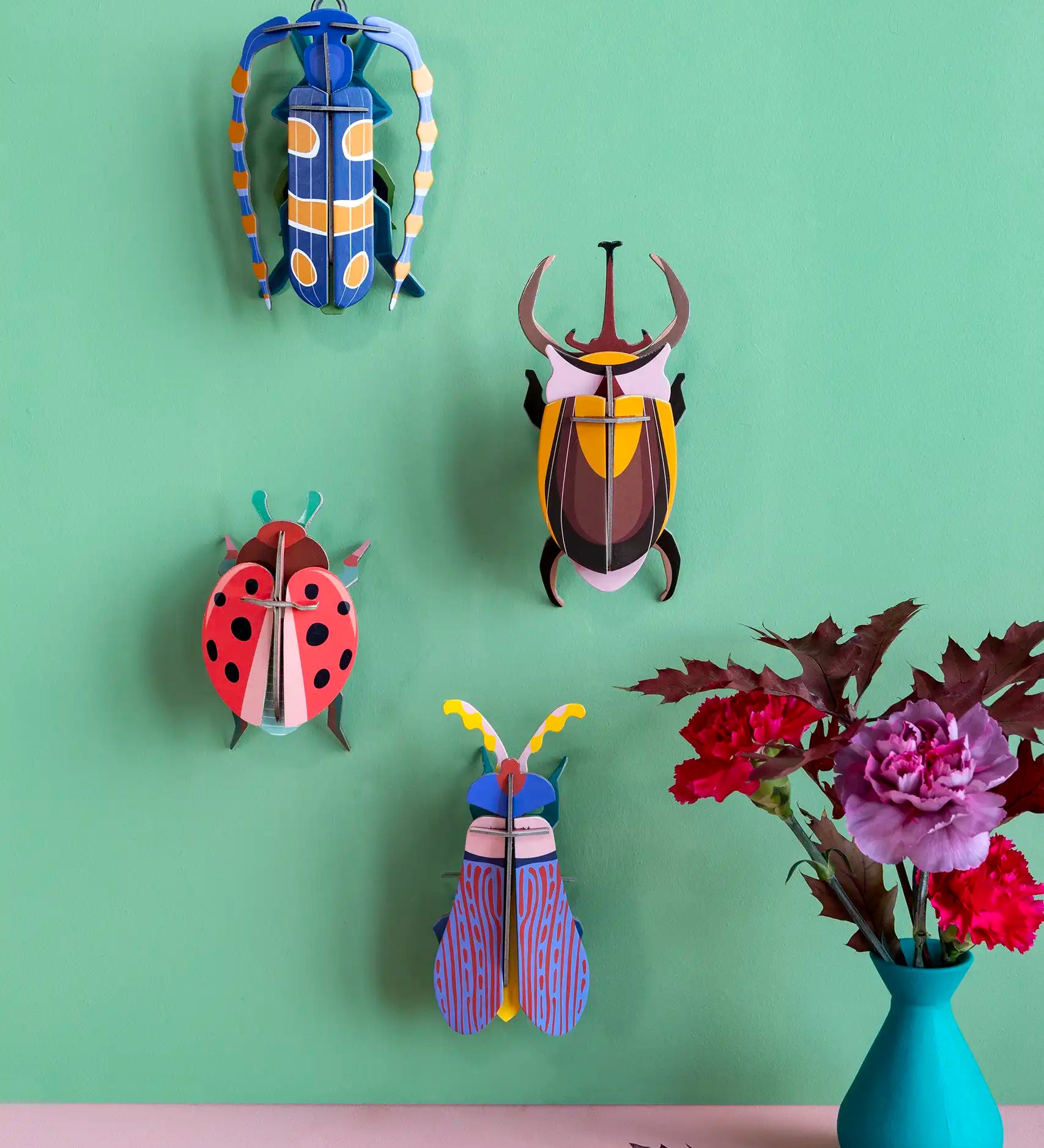 Studio Roof Insect Coccinelle wall art craft kit decoration assembled and displayed on a green wall.