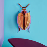 Studio Roof 3D cardboard Cuprum beetle craft kit displayed on a wall 