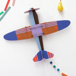 a cardboard model plane with geometric patterns and bright colours
