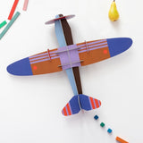 a cardboard model plane with geometric patterns and bright colours