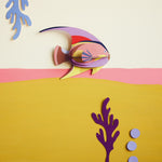 Studio Roof card craft fish on a pink and yellow wall next to some card plants