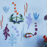Studio Roof plastic-free craft sea creature wall decorations on a white background next to a potted plant