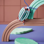 Studio roof eco-friendly cardboard rainbow lead slotting model bug climbing on a green and brown arch above some model leaves