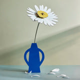 Studio Roof daisy everlasting flower cardboard flower decoration shown built and displayed in a blue vase.