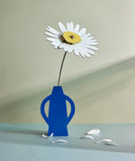 Studio Roof daisy everlasting flower cardboard flower decoration shown built and displayed in a blue vase.