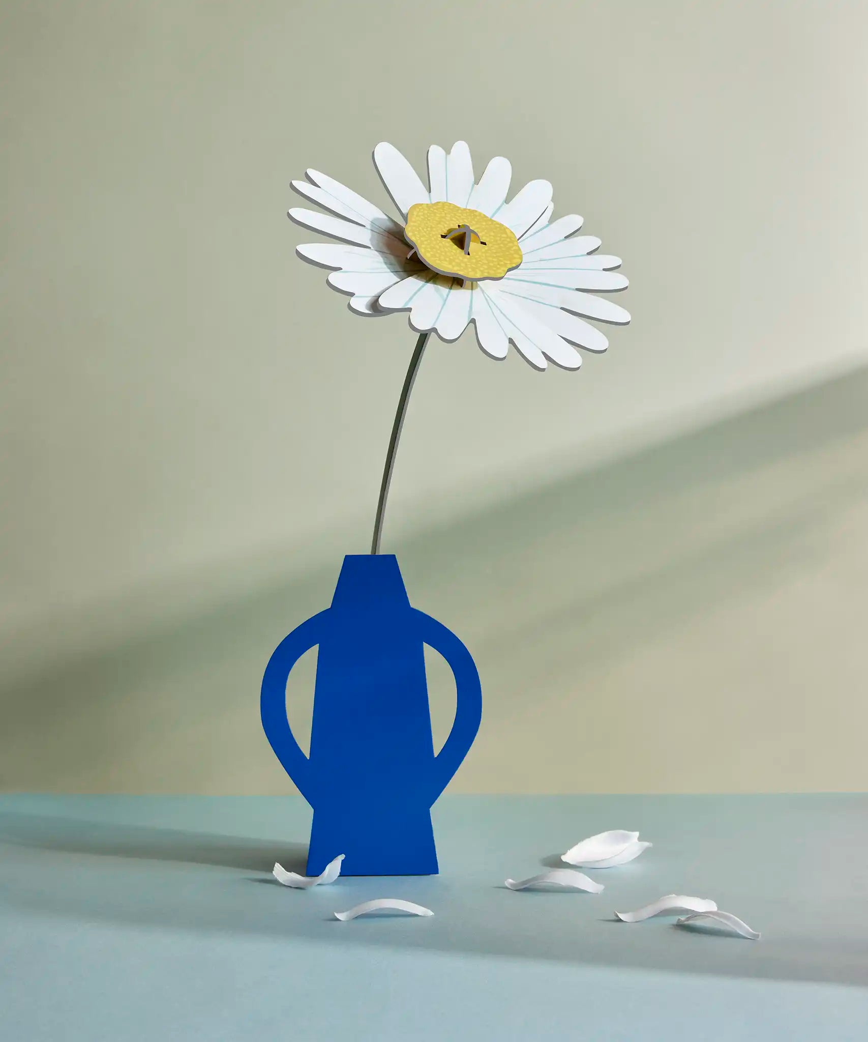 Studio Roof daisy everlasting flower cardboard flower decoration shown built and displayed in a blue vase.