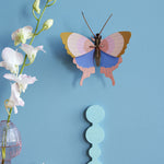 Studio Roof Gold Rim Butterfly decoration picyured on a blue painted wall