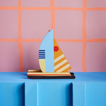 a cardboard model boat with geometric patterns and bright colours