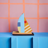 a cardboard model boat with geometric patterns and bright colours