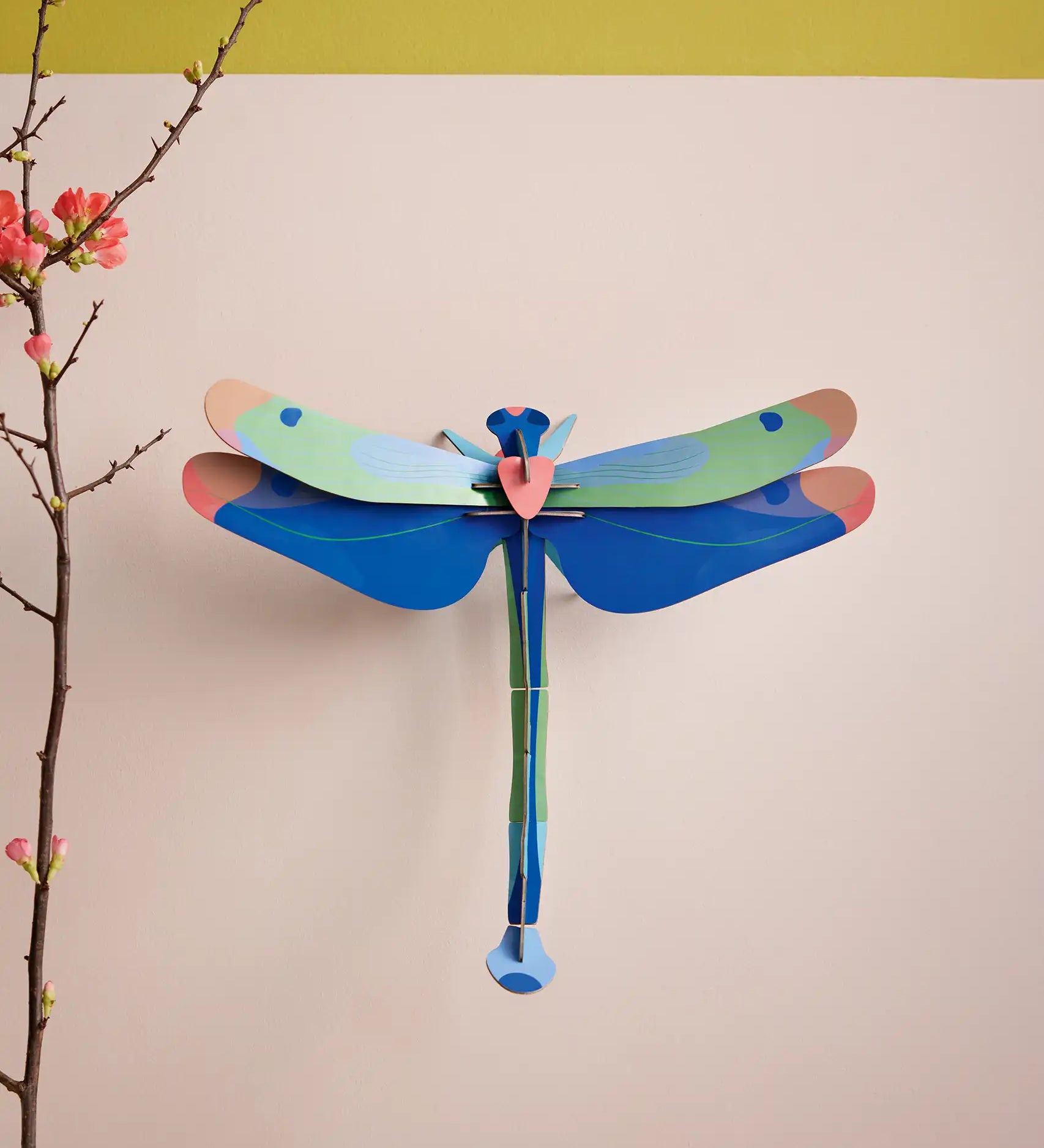 Studio Roof Blue Dragonfly Cardboard Wall Art shown built and displayed on a wall.
