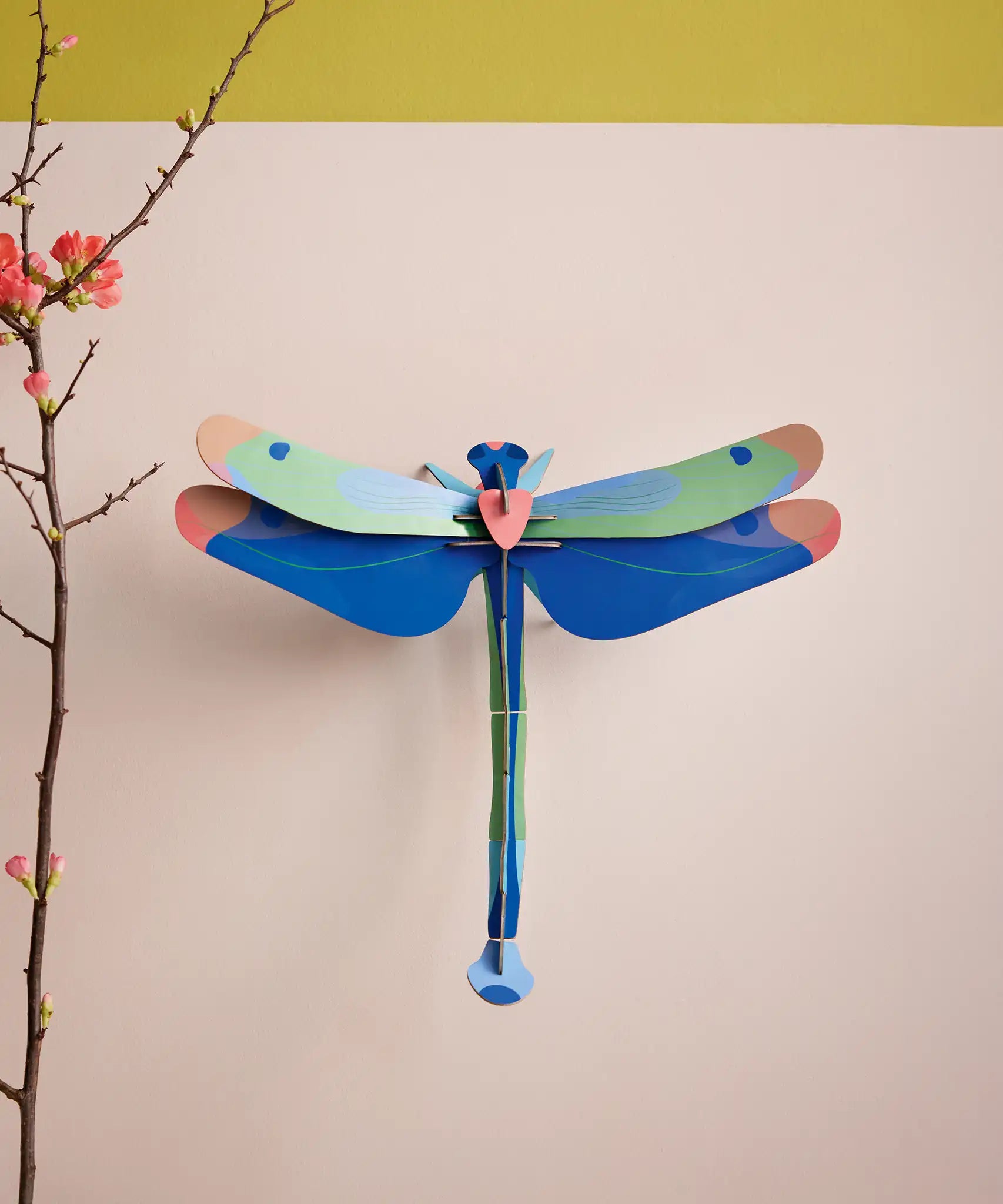 Studio Roof Blue Dragonfly Cardboard Wall Art shown built and displayed on a wall.