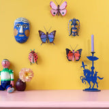 Studio Roof Insect and Butterflies DIY wall art kits assembled and displayed on a yellow wall. 