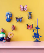 Studio Roof Insect and Butterflies DIY wall art kits assembled and displayed on a yellow wall. 