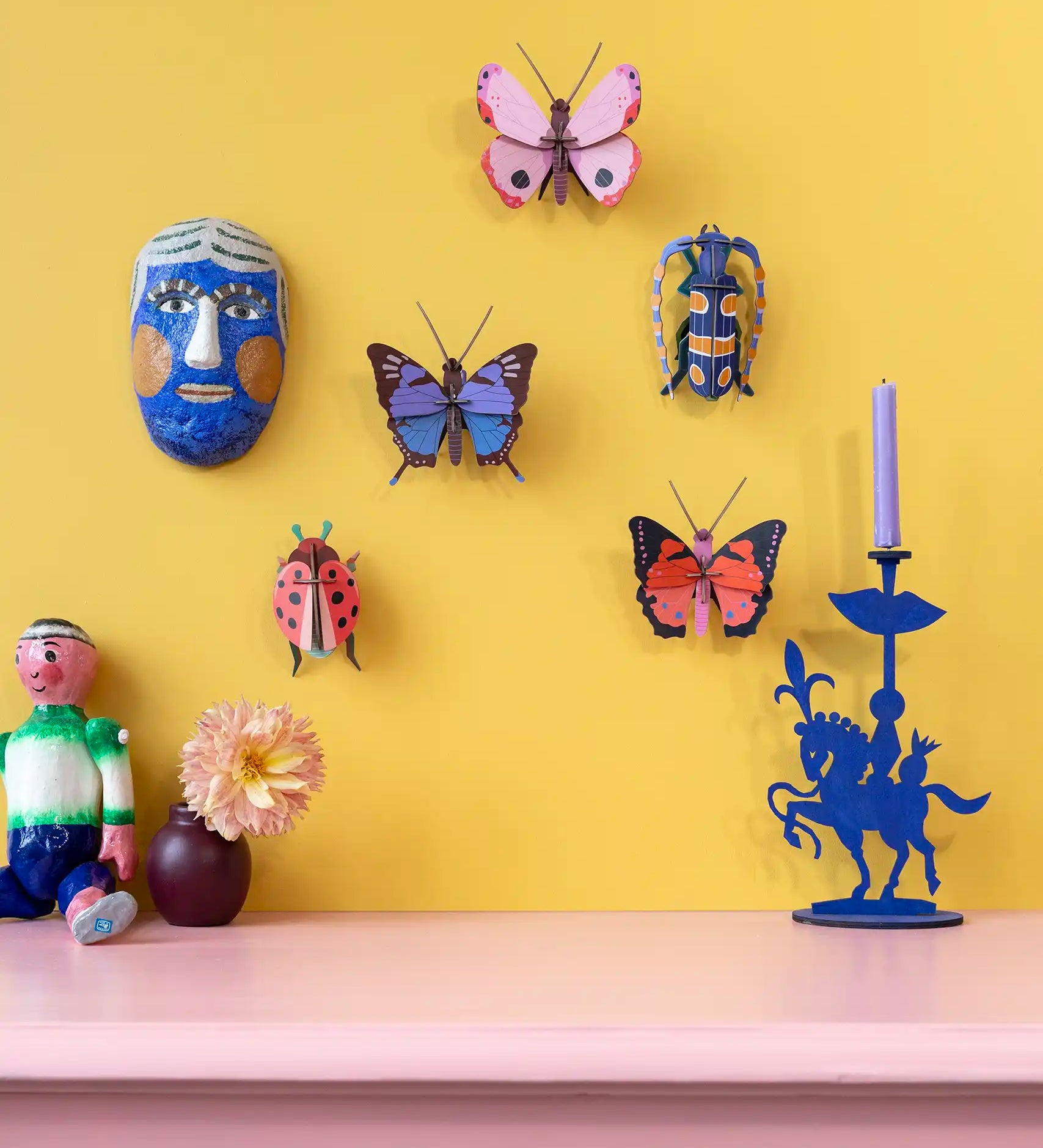 Studio Roof Insect and Butterflies DIY wall art kits assembled and displayed on a yellow wall. 