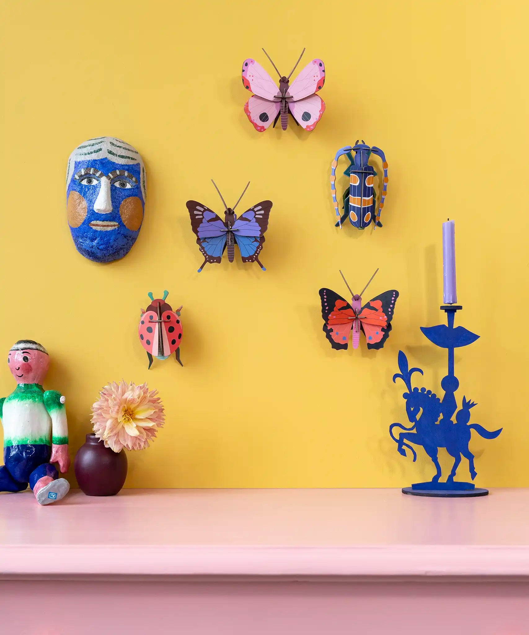 Studio Roof Insect and Butterflies DIY wall art kits assembled and displayed on a yellow wall. 